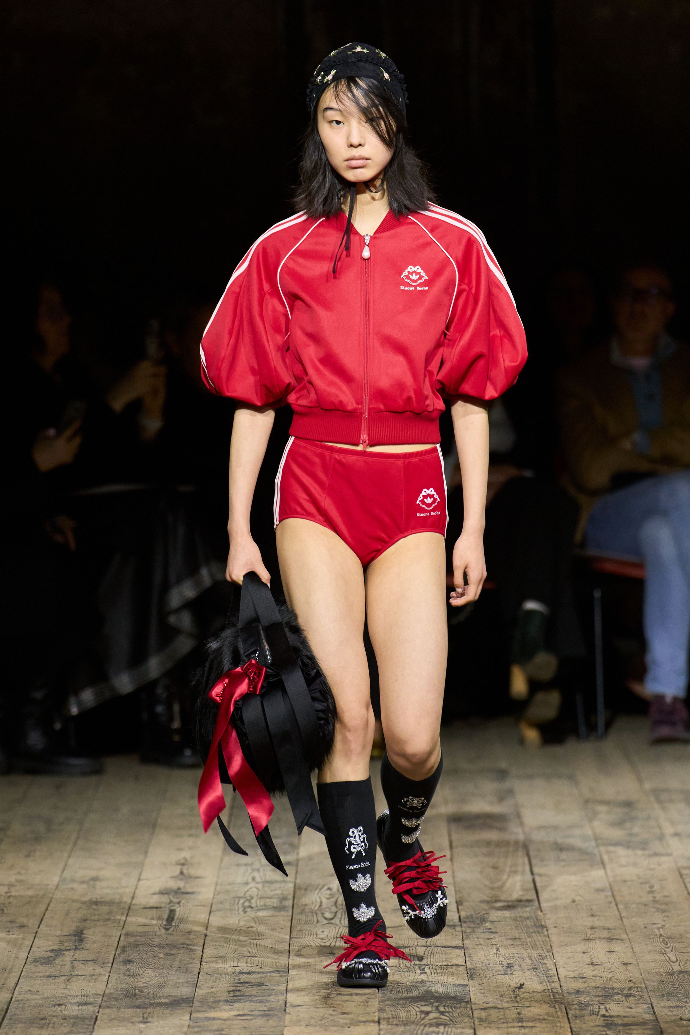 Simone Rocha以学院风与运动元素碰撞，红色运动套装、宽松针织与装饰花卉细节交织出甜美与叛逆并存的青春张力，在木质秀场中延续品牌的浪漫怪诞气质-顽石频道趋势研究
